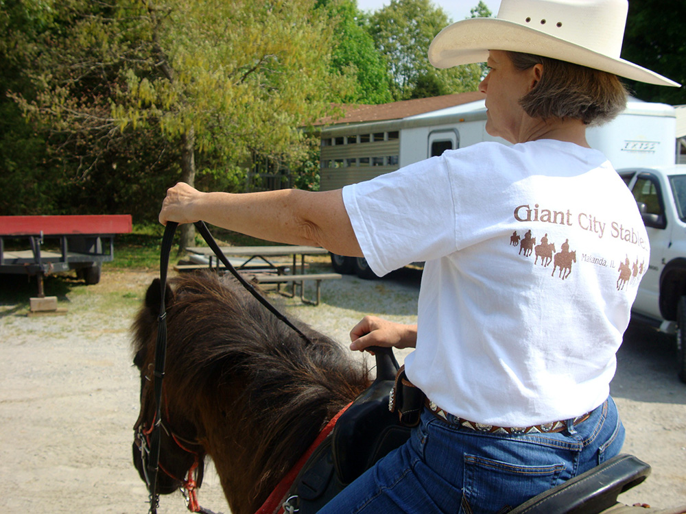 Person on horseback holding reins in left hand showing how to turn left